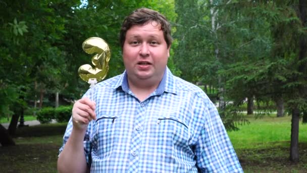 Big man innehar Golden Balloon gör 3 nummer utomhus. 3: e jubileumsfest — Stockvideo