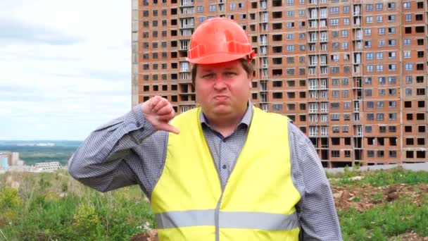 Mannelijke bouwer voorman, arbeider of architect op bouwplaats van de site met duim omlaag en op zoek naar camera — Stockvideo