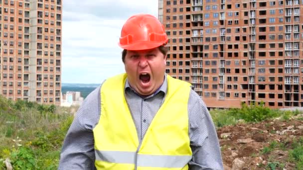 Männlicher Bauleiter, Arbeiter oder Architekt auf der Baustelle schreit und blickt in die Kamera — Stockvideo