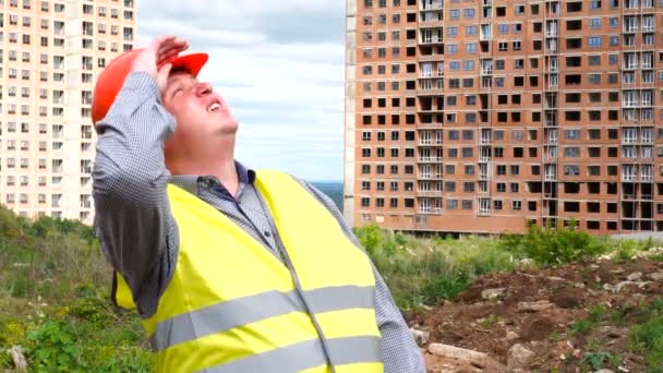 Строитель мужчина бригадир, рабочий или архитектор на строительной площадке оглядывается вокруг — стоковое видео