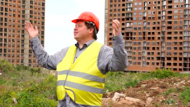 Mannelijke bouwer voorman, werknemer of architect op bouwplaats site trots toont resultaten terwijl het verhogen van zijn armen — Stockvideo