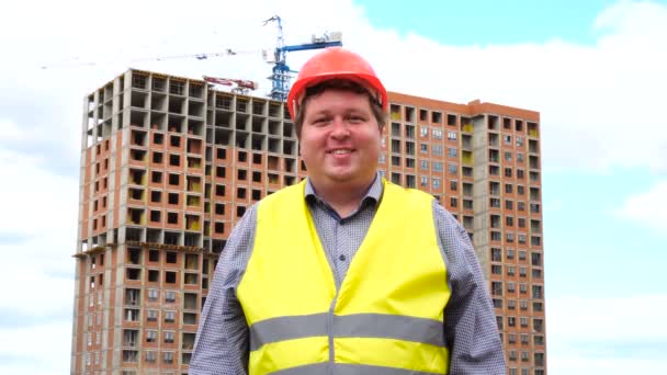 Mężczyzna budowniczy, pracownik lub architekt na budowie budynku uśmiechnięty do kamery — Wideo stockowe