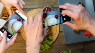 Yiyecek fotoğrafları çekmek için akıllı telefon kullanan çift