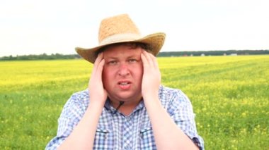 Yakın çekim üzgün genç çiftçi endişeli yüz ifadesi ile. Baş ağrısı ile kovboy şapkalı adam.
