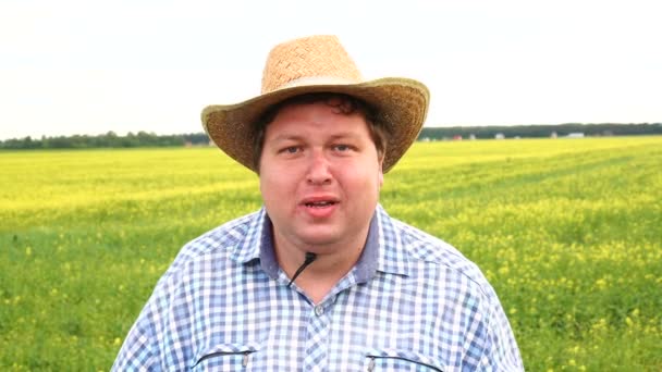 Statný farmář stojící v terénu a výkřiky, na slunný den nosí kovbojský klobouk. Člověk v depresi, malátnosti, smutku — Stock video