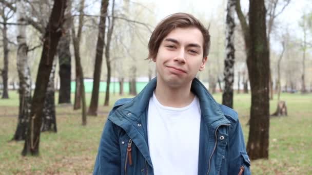 Nahaufnahme eines jungen gutaussehenden kaukasischen Mannes, der zunickt und in die Kamera schaut — Stockvideo