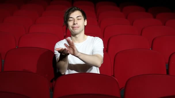 Hombre sentado solo y aplaudiendo en la sala de cine vacía o teatro — Vídeo de stock
