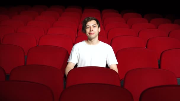 Homem sentado sozinho em sala de cinema vazia ou teatro — Vídeo de Stock