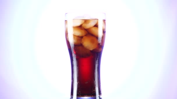 Ein Glas Cola dreht sich langsam um die eigene Achse. Nahaufnahme 4k Video. weißer Hintergrund. — Stockvideo