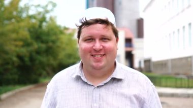 Şehirde mutlu müslüman adam göz kırpıyor ve gülümsüyor