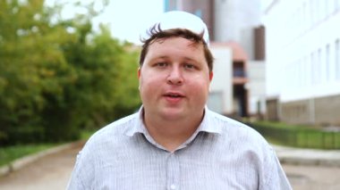 Şehirde genç Müslüman adam kamerada konuşuyor