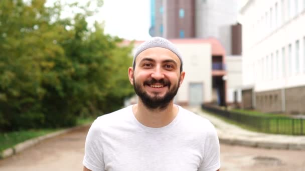 Knappe gelukkige bebaarde moslim man in de stad lachend — Stockvideo