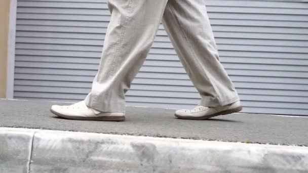 Disparo de los pies de los hombres en zapatos caminando por la carretera de baldosas. Medio ambiente urbano — Vídeos de Stock