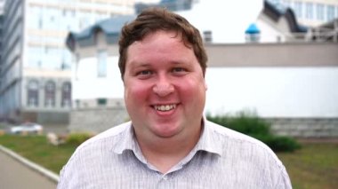 Göz kırparak yakışıklı gülümseyen genç adam portresi. Kameraya bakan duygusal erkekler