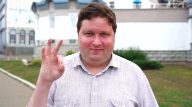 Ok işareti gösteren yakışıklı gülümseyen genç adam portre. Kameraya bakan duygusal erkekler