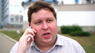 Yakışıklı ciddi genç adam portre kim akıllı telefon konuşuyor. Kameraya bakan duygusal erkekler