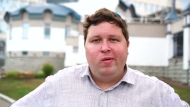 Sakız çiğneyen yakışıklı şişman genç adam portresi. Kameraya bakan duygusal erkekler