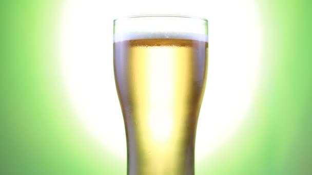 水滴が入ったグラスの中の淡いラガービール。クラフトビールクローズアップ。回転 — ストック動画