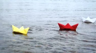 Dört çok renkli kağıt tekneler romantik gün batımında su üzerinde yelken. Origami.