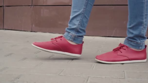 Woman is walking in city in daytime in autumn, close-up view of her red shoes, strolling — Stock Video