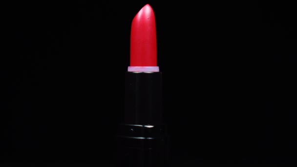 Rouge à lèvres ton rouge se déplaçant tournant sur fond noir. Maquillage de près professionnel et beauté, rotation — Video