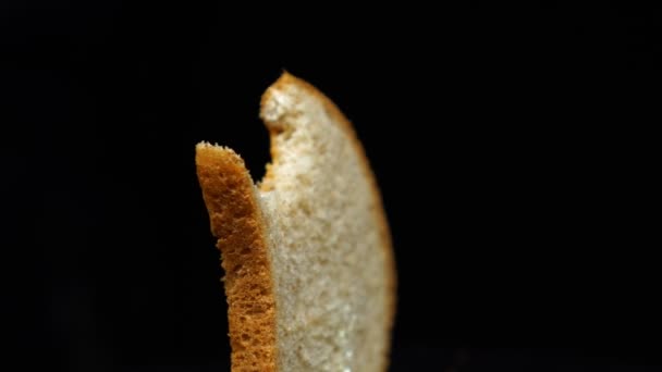 Bitten φέτα του τοστ ψωμί περιστρέφεται, απομονώνονται πάνω από το λευκό φόντο — Αρχείο Βίντεο
