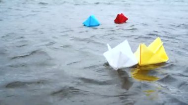Dört çok renkli kağıt tekneler romantik gün batımında su üzerinde yelken. Origami