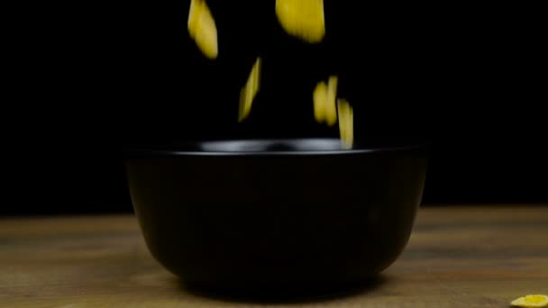 Copos de maíz dorado para el desayuno relleno en un tazón en una mesa de madera, deliciosa comida saludable — Vídeo de stock