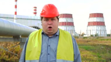 İşçi, mühendis ya da elektrikçi bir elektrik santralinin önünde ağzını açtı.