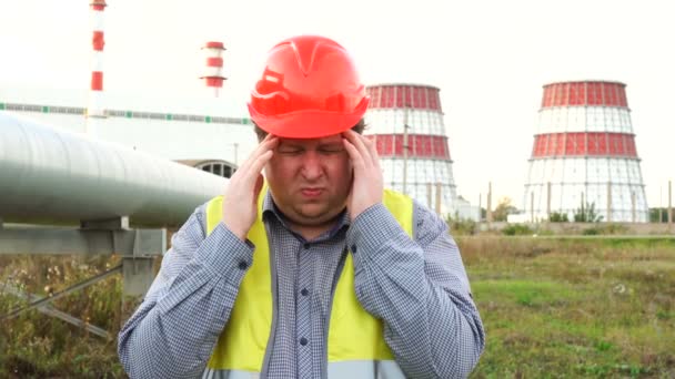 Nieszczęśliwy pracownik, inżynier lub elektryk z bólem głowy lub stresem stojący przed elektrownią — Wideo stockowe