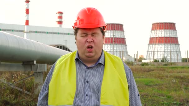 疲れた労働者、技術者、電気技師は、発電所の前に立って、あくびをし、眠りに落ちる — ストック動画