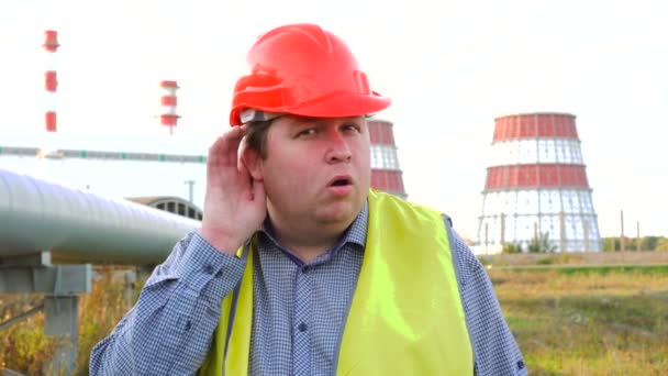 Trabajador, ingeniero o electricista mirando directamente a la cámara escuchando a escondidas frente a una central eléctrica — Vídeos de Stock