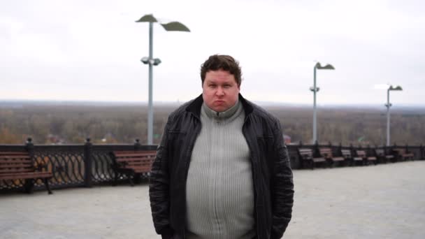 Zoom in portrait of fat angry man looking at camera outdoor — Stock Video