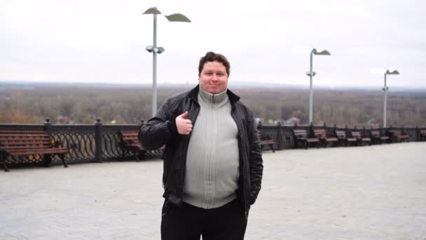 Zoom avant portrait de gros homme regardant la caméra et montrant pouce vers le haut — Video