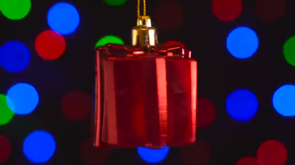 Jul dekoration, röd gåva hängande på bokeh bakgrund blinkande ljus — Stockvideo