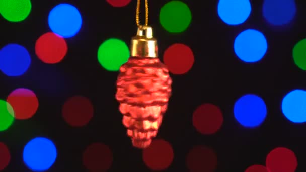 Décoration de Noël, cône rouge suspendu sur le fond bokeh de lumières clignotantes — Video