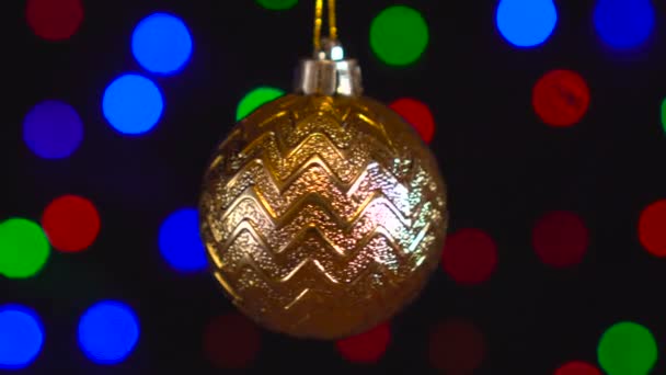 Decoración de Navidad, bola de oro colgando en el fondo bokeh de luces intermitentes — Vídeos de Stock