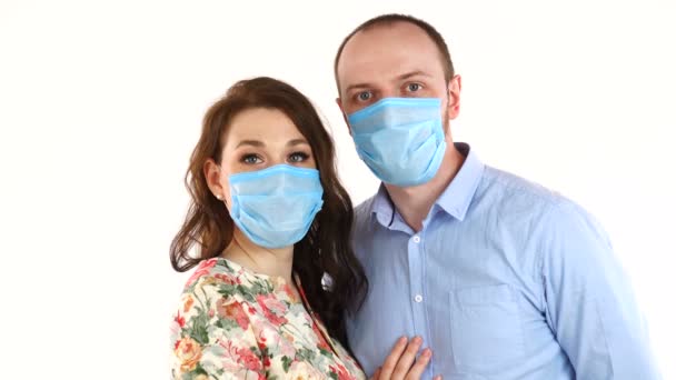보호 마스크를 쓰고 있는 젊은 부부는 흰 배경에 따로 떨어져 있다 — 비디오