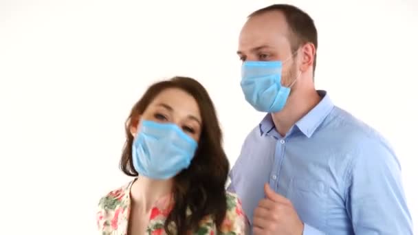 Mladý pár v ochranné masky tanec a baví na bílém pozadí — Stock video