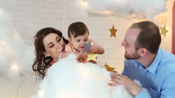 Jeune famille heureuse jouant avec un bébé s'amusant dans le salon — Video