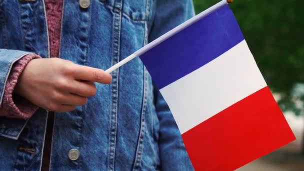 Cámara lenta: Mujer irreconocible con bandera francesa. Chica caminando por la calle con la bandera nacional de Francia — Vídeos de Stock