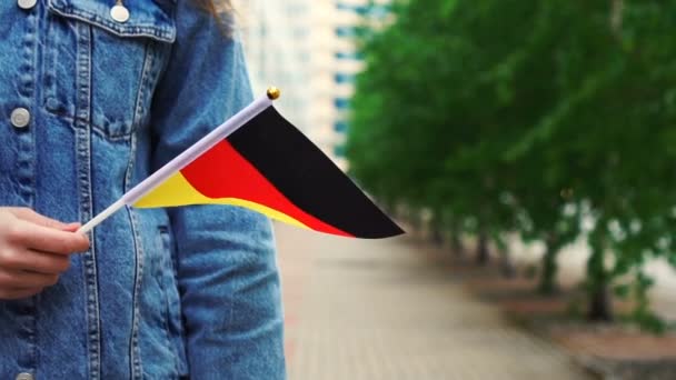 Slow motion: Onherkenbare vrouw met Duitse vlag. Meisje loopt door straat met nationale vlag van Duitsland — Stockvideo