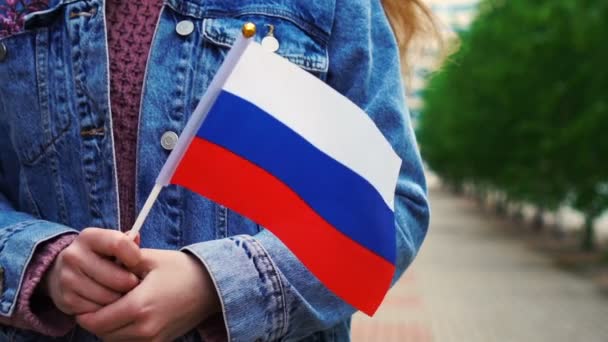 Slow motion: Onherkenbare vrouw met Russische vlag. Meisje loopt door straat met nationale vlag van Rusland — Stockvideo