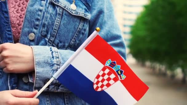 Slow motion: Unrecognizable woman holding Croatian flag. Girl walking down street with national flag of Croatia — Stock Video