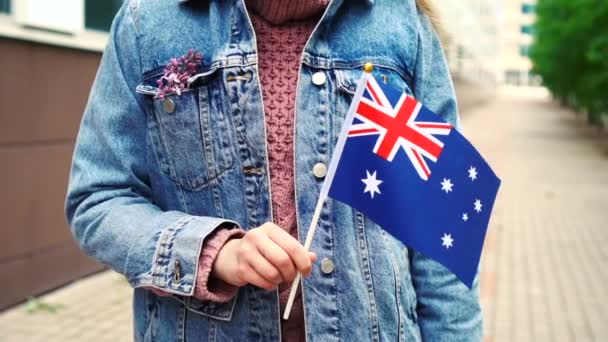 Медленное движение: Неузнаваемая женщина с австралийским флагом. Девушка идет по улице с национальным флагом Австралии — стоковое видео
