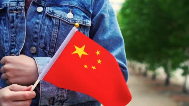 Lassú mozgás: felismerhetetlen nő kezében kínai zászló. Lány sétál az utcán a nemzeti zászló Kína — Stock videók
