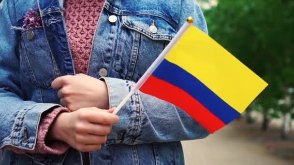 Cámara lenta: Mujer irreconocible con bandera colombiana. Chica caminando calle abajo con bandera nacional de Colombia — Vídeos de Stock
