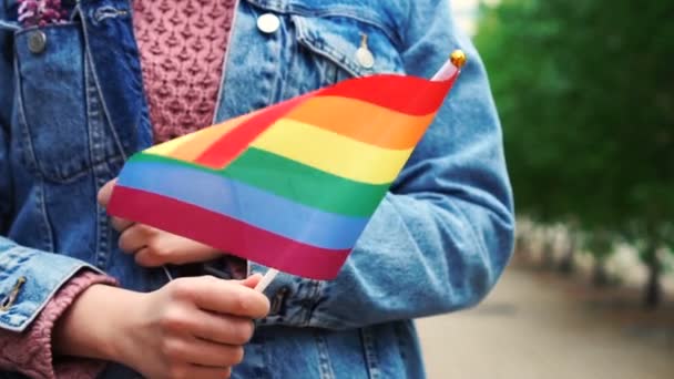 Cámara lenta: Mujer irreconocible con bandera de arco iris. Chica caminando por la calle con gay arco iris bandera — Vídeos de Stock