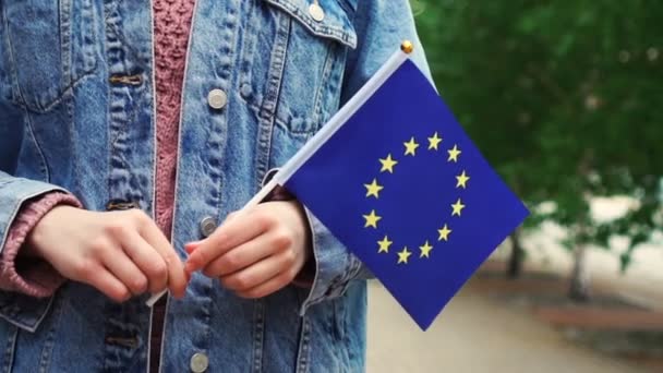 Cámara lenta: Mujer irreconocible con bandera de la Unión Europea. Chica caminando por la calle con bandera europea — Vídeos de Stock