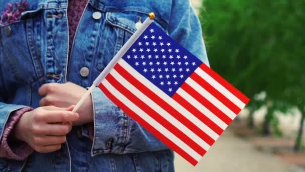 Movimento lento: Mulher irreconhecível segurando bandeira americana. Menina andando rua abaixo com bandeira nacional dos Estados Unidos da América — Vídeo de Stock